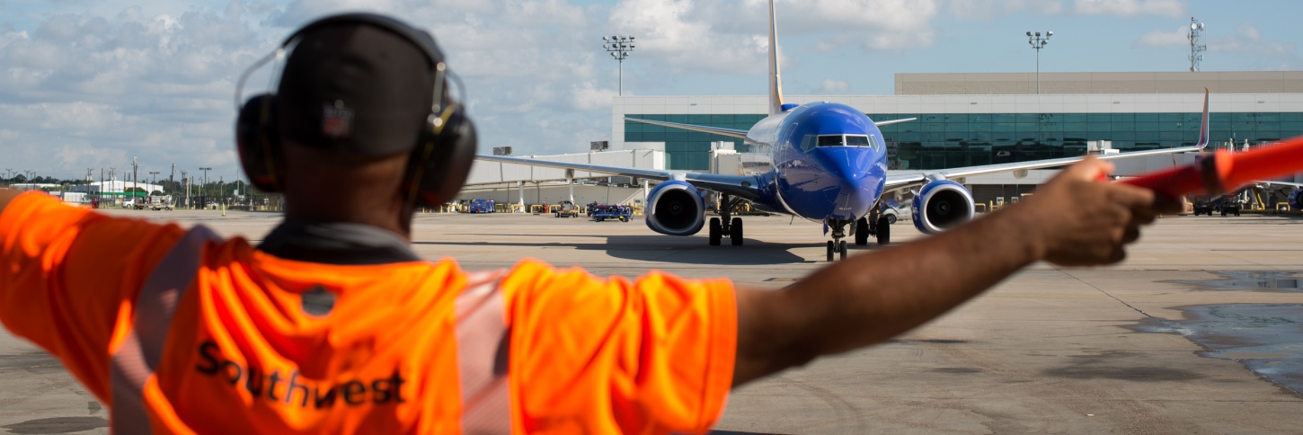 A Southwest Ramp Agent waves in a plane